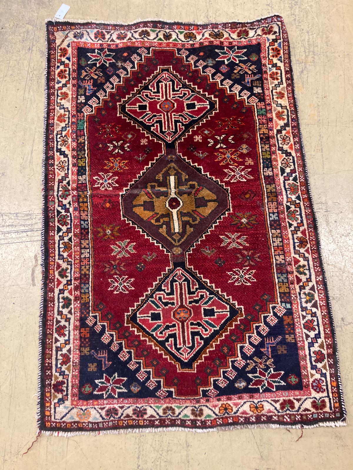 A small Kasak rug with three medallions on a crimson ground, 148 x 95cm